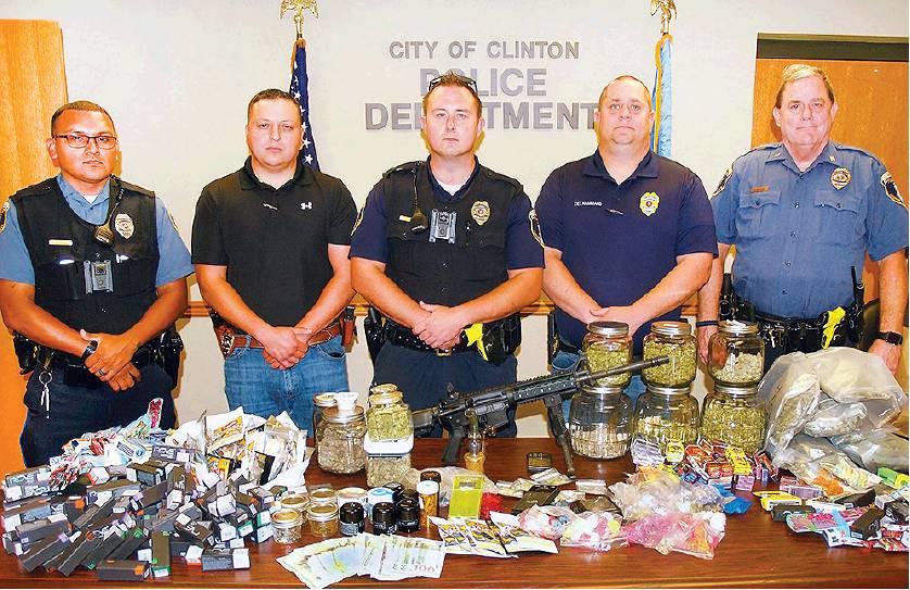 CDN | Robert S. Bryan                      Clinton police stand behind a table loaded with illegal drug products confiscated Friday from a house on N. 20th Street. From the left are Patrolman Mario Cedillo, Detective Lt. Luis De La Torre, Patrolman Je