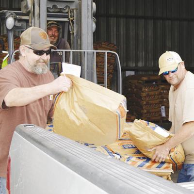Tommy Wise brings a pallet of cattle feed to be unloaded by Lawerance Southerland, left, and Kelly Beaver Wednesday at the Farmers Co-Op in Clinton. CDN | Christian Jacobsen