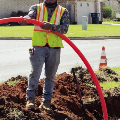 Cesar Reyes places fiber optic cables at Acme Brick Park. CDN | Christian Jacobsen