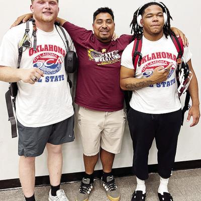 Malachi Lorne, right, celebrates with teammate Marcus Wilson, left, and Clinton wrestling assistant coach Josue Martinez after his bout Wednesday in the All-State wrestling match in Catoosa. CDN | Courtesy photo