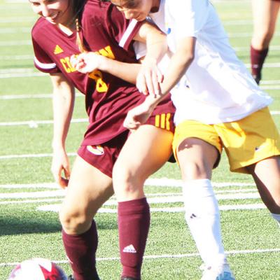 Brien fights off a defender for the ball during the Lady Reds match against Classen SAS earlier in the season. Lindsay Brien prefers soccer over volleyball