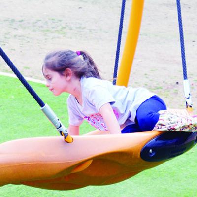 Paizley Arriaga, 5, climbs onto a swing at McLain Rogers Park. CDN | Michael Maresh