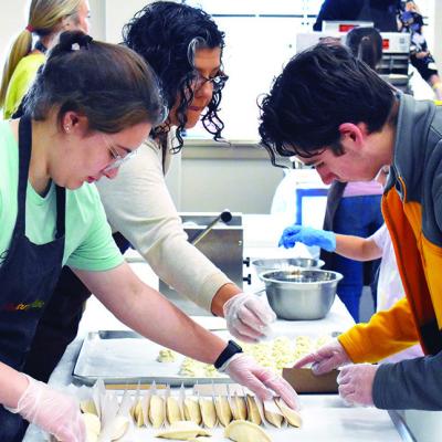 Corn Bible Academy students and parents preparing vernika and making the filling for the upcoming CBA German Feast and Auction, from left, are Devyn Walters, Mikki Penner and Lachlan Penner. CDN | Courtesy photo German Feast preparation