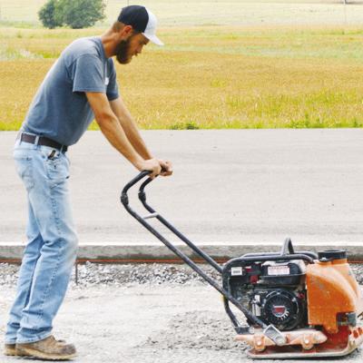Caleb Yoder compacts the gravel in order to level the foundation and “bring it up to grade” for the future T-hangar installation at Clinton Regional Airport. CDN | Christian Jacobsen