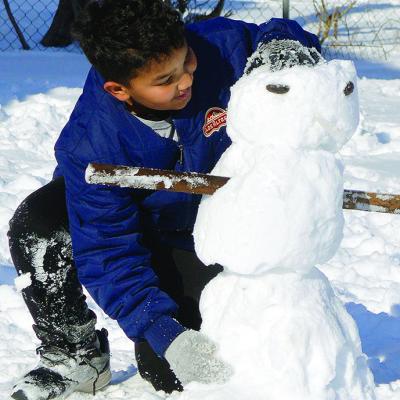 Jakob West enjoys the winter weather by making a snowman in his backyard Monday afternoon. CDN | Micah Ashcraft
