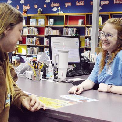 Myra Whitney, left, receives help signing up for the 2026 WPLS Winter Reading Challenge from Librarian Madison Wright at the Clinton Public Library. CDN | Micah Ashcraft