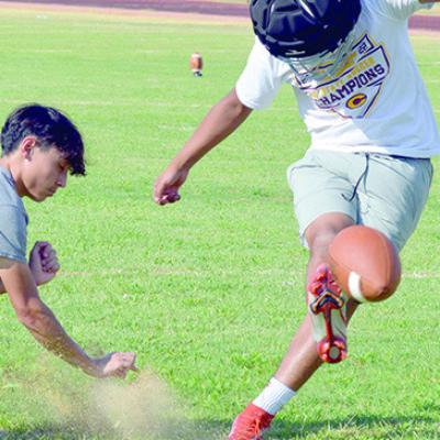 Cameron Castro, left holds the ball down and Sammy Velez kicks the ball during football practice Tuesday. CDN | Josh Jennings Clinton prepares for scrimmage at Newcastle