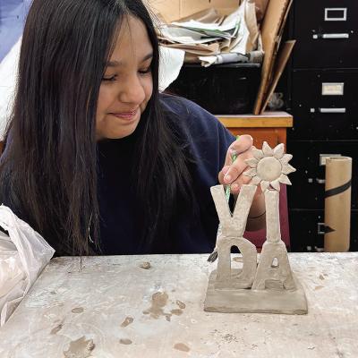 Omelda Lovos works on her clay miniature word sculpture at Clinton High School. Her class made them as a tribute to Robert Indiana’s Love sculpture. CDN | Courtesy photo