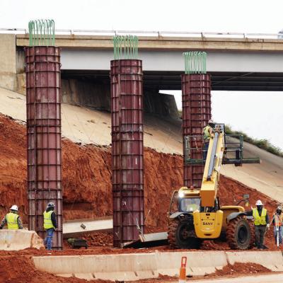 Construction crews install new support pillars for the Intestate 40 overpass Tuesday at Neptune Drive. CDN | Christian Jacobsen