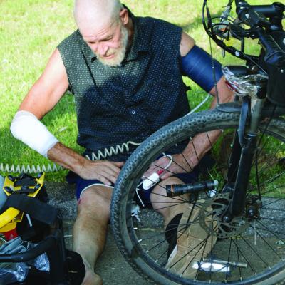 Jeff Keeton recovers after he said three local dogs ran up to him on his bike and tried to bite him Friday morning at N. 14th and Prairie Chief Avenue. He said he was fine with no broken bones, and only a road rash to his arm and knee. CDN | Christian Jac
