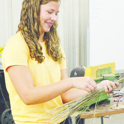 Arapaho-Butler’s Georgia Rose works to bundle together straws of grass during her agriculture class Monday morning. CDN | Micah Ashcraft