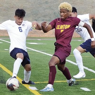 No. 7 Deontray Beavers, center, fights against two Nathan Hale defenders during Clinton’s home playoff win Friday against the Rangers. CDN | Sam Goodwyn Clinton Reds soccer one step closer to fourth straight title