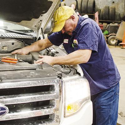 Nate Burnett works on one of the vans at the Clinton Bus Barn. CDN | Sam Goodwyn