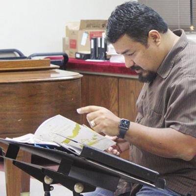 Xavier Abraham prepares to conduct those in attendance to sing Christmas carols at the Christmas Choir rehearsal. Christmas Community Choir