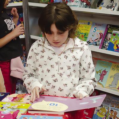 Deliah LaRue looks at a book from the Book Fair at Southwest Elementary School. CDN | Christian Jacobsen