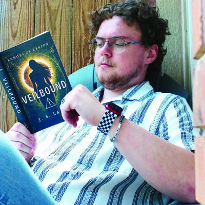 Jeston Laney reads his book “Veilbound” at his home in Weatherford. CDN | Courtesy photo