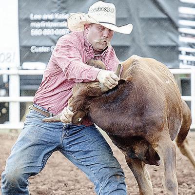 Hunter Washburn wrestles the steer during the rodeo Saturday at the Clinton Round-Up Club Arena. CDN | Sam Goodwyn