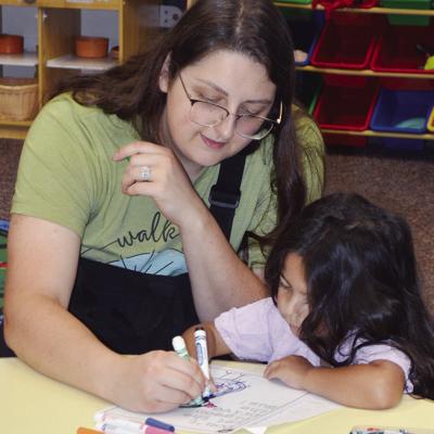 Miraonna, left, and Nayeli Cardenas are applying color to a “The Duckling Gets a Cookie” coloring page Tuesday at the Clinton Public Library. CDN | Christian Jacobsen