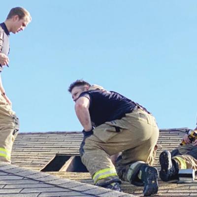 Above from left, Firefighter Tyler Calvert, Lt. Joe Williams and Firefighter Calvin Baggett work to patch a ventilation hole in the roof after the fire was out at 18 Lombardy Place. Firemen respond to blaze on Lombardy