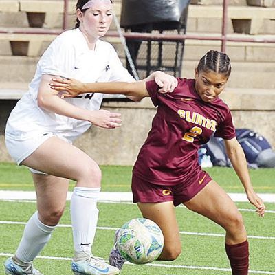 Clinton’s No. 2 Sammy Meraz fights a Heritage Hall defender for the ball during the Lady Reds’ home game Monday against the Lady Chargers. CDN | Sam Goodwyn