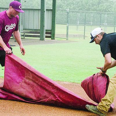 Rhett Blundell, left, and Lyndon Perry unroll a tarp to put on one of the fields at Schumacher Fields at Acme Brick Park Tuesday to protect it from the rain. CDN | Sam Goodwyn