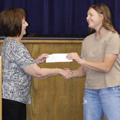 Linda Elston, left, awards the ESA Alpha Nu Scholarship to Malley Baker Wednesday during the Senior Awards Ceremony at the A-B Auditorium. CDN | Christian Jacobsen
