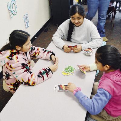 Southwest Elementary third-graders, from left, Justice Twins, Vanessa Nava and Daniela Barco play cards Wednesday morning inside for recess due to single-digit temperatures outside. CDN | Michael Maresh
