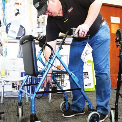 Western Medical Equipment Branch Manager Billy Goodwin shows the benefits of a rollator inside the store. Goodwin helps people get moving