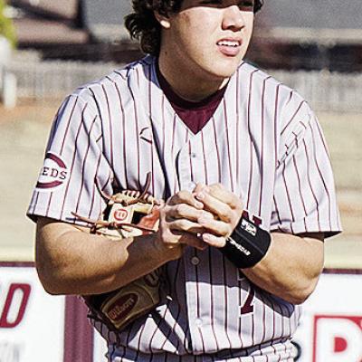 Clinton’s Easten Powell rubs the ball as he prepares to pitch during the Reds’ spring home game against El Reno. CDN | Sam Goodwyn