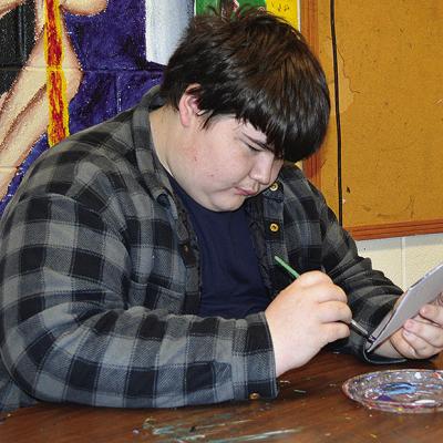 Colton Ackerman adds additional color to his abstract art piece Thursday at Clinton High School. CDN | Christian Jacobsen