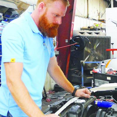 Jake Gutermuth looks under the hood of a customer’s vehicle at McKinsey Motors. CDN | Micah Ashcraft