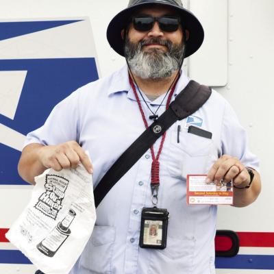 Mail Carrier Matthew Lantz drops off plastic bags to residents during his morning route for the Stamp Out Hunger Food Drive in Clinton. CDN | Christian Jacobsen