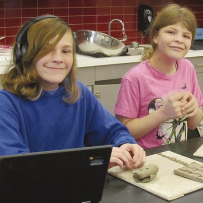 Justin Schenewolf, left and Kayla Nitche mold clay into a tictac-toe board and pieces. CDN | Christian Jacobsen