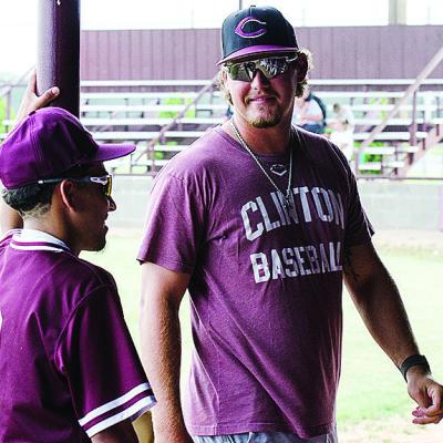 New Clinton baseball coach Cooper Rhoads, right, talks with Azreal Fierros prior to the start of the Reds’ home game against Weatherford this summer. CDN | Sam Goodwyn