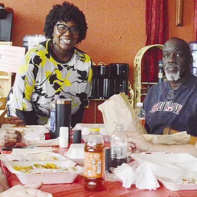 From left, Shelly Ramey, Gwen Bagby, H.O.S.T. Ministries Pastor Wilma Jackson, Lindell Brown, and Ethel Isbell break bread together during the recent H.O.S.T. Ministries community Christmas meal.