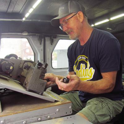 Lomax Lee of A-OK Lock &amp; Key cuts and shapes a new house key for a customer in the A-OK work van. CDN | Christian Jacobsen