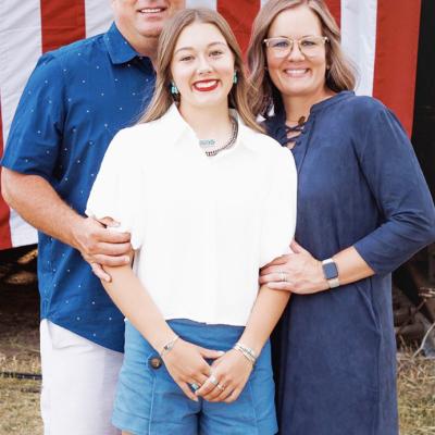 New Clinton offensive coordinator Garrett Harland, left, smiles with his daughter Aubren, center and wife Kambri. CDN | Courtesy photo
