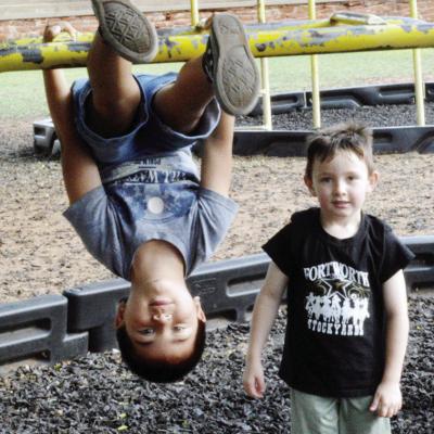 Gabriel Gonzalez wanted to hang upside down while Jimi Haag jumped into the photo Friday at Nance Elementary. CDN | Christian Jacobsen