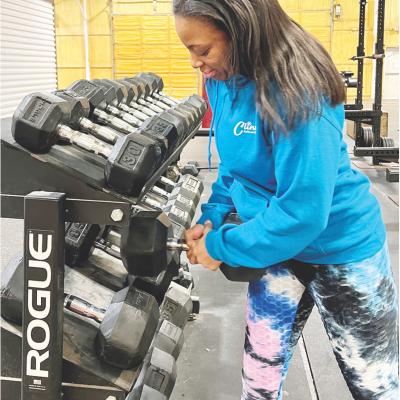 Trisha Hester prepares for the New Year’s rush at Acme Brick Park Fitness Center by organizing dumbbells. CDN I Emily Stephens Acme preps for New Year
