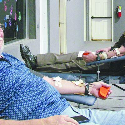 Tim Ruyle, left, and OHP Cmdr. Chance Husted donate double the amount of blood Tuesday for the Our Blood Institute blood drive at First Christian Church. CDN | Christian Jacobsen