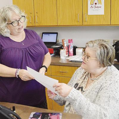 Patti Esparza, left, and Michelle Thompson check on school Tshirt orders while at the front desk at Washington Elementary School. CDN | Micah Ashcraft