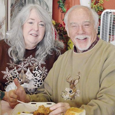 Tommie Walker and Bill Walker smile together as they enjoy a free meal during the H.O.S.T. Ministries’ Community Christmas Meal. CDN | Micah Ashcraft