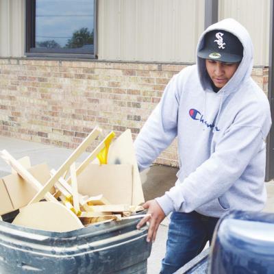 Gabriel Maddox gets ready for Clinton Cleanup Day, pulling a bin full of trash to his truck bed to haul off. CDN | Collin Wieder Residents prepare for major spring cleaning on Saturday