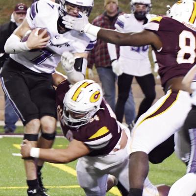 Clinton’s No. 54 Layden Fuller wraps up the Bethany quarterback with No. 84 Montiel Crane coming in to help finish the play. The Red Tornado defense proved stout much of the season. CDN | John Kinsey High, low tackle