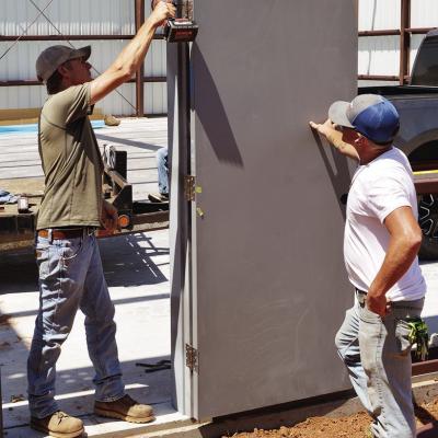 Dusty Heller, left, attaches the door to the frame of the new box hangar as Scott Oats helps keep the door in place Monday at Clinton Regional Airport. CDN | Christian Jacobsen