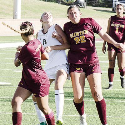 Clinton’s Aaliyah Lopez, right, heads the ball to her teammate Sammy Meraz, left, while fighting off the Harding Charter defender during the Lady Reds’ blowout win Monday at home over the Lady Eagles. CDN | Sam Goodwyn