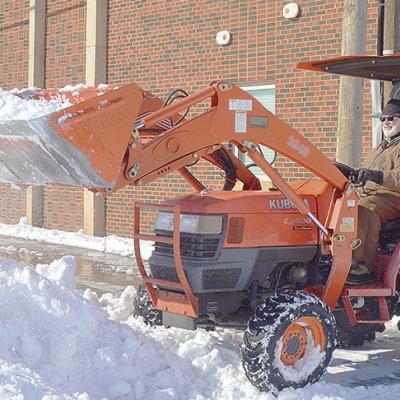 Joe Brown uses a small tractor to clear out the snow Monday morning from the parking area next to First Baptist Church. CDN | Micah Ashcraft