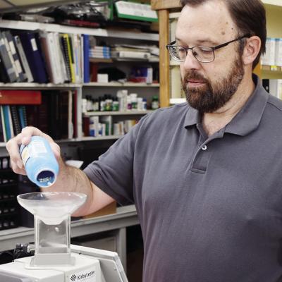 Owner Scott Campbell measures out prescriptions behind the pharmacy counter at S&D Drug at 915 Frisco Ave. CDN | Caleb Blanchard Owner Scott Campbell measures out prescriptions behind the pharmacy counter at S&D Drug at 915 Frisco Ave