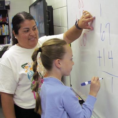 Brenda Martinez is helping Vivien Salinas carry the one in twodigit addition at Southwest Elementary School. CDN | Christian Jacobsen