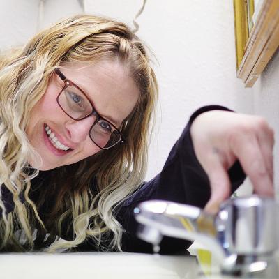 Kody Thompson sets the bathroom faucet to a drip Friday morning in one of the guest rooms at Days Inn in expectation of today’s frigid temperatures. CDN | Micah Ashcraft